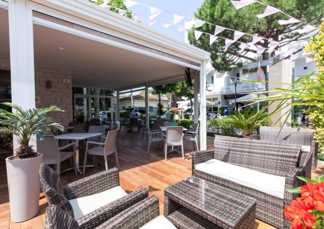 Stylish outdoor terrace with woven chairs and plants.
