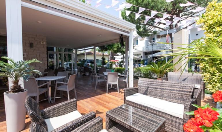 Stylish outdoor terrace with woven chairs and plants.
